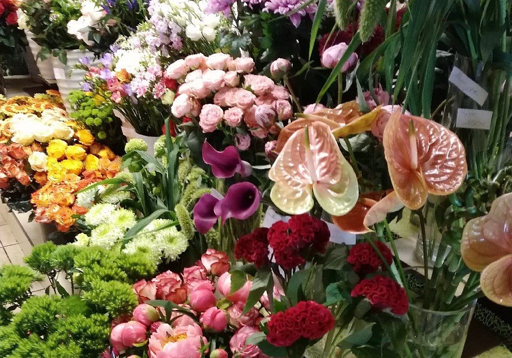 Vielfältige Blumenkomposition mit Rosen, Anthurien und weiteren Blüten in kräftigen Farben